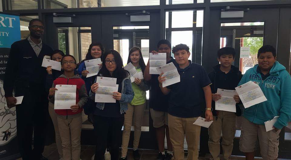 Students at Conrad High School show off their acceptance letters to a collegiate academy.