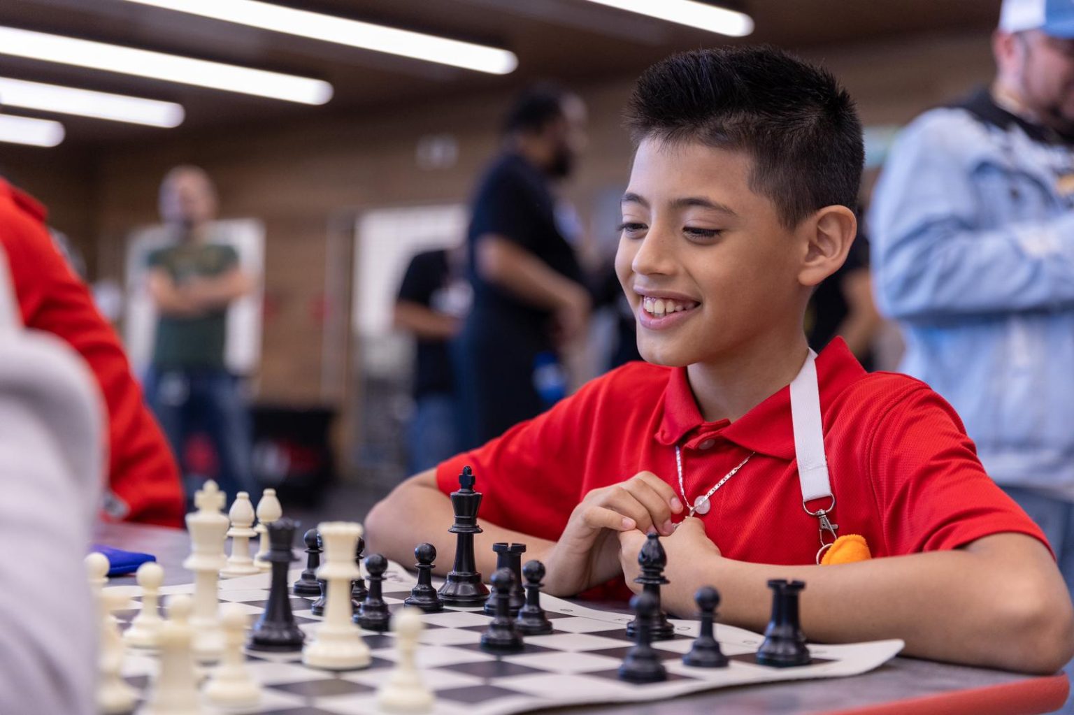 Student in red shirt playing chess